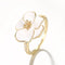Bague en or ornée d’une fleur en émail blanc avec des accents en cristal.
