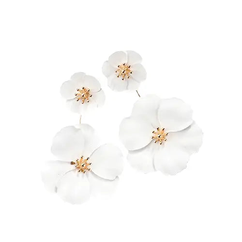 Boucles d’oreilles florales blanches avec centres dorés.