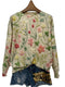 Pull-over en tricot floral avec des fleurs brodées roses, jaunes et vertes sur un fond crème.
