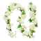 Guirlande de fleurs blanches artificielles avec des feuilles vertes tissées.