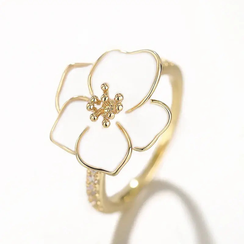 Bague en or ornée d’une fleur en émail blanc.