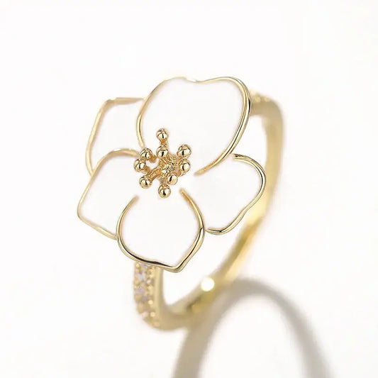 Bague en or ornée d’une fleur en émail blanc.