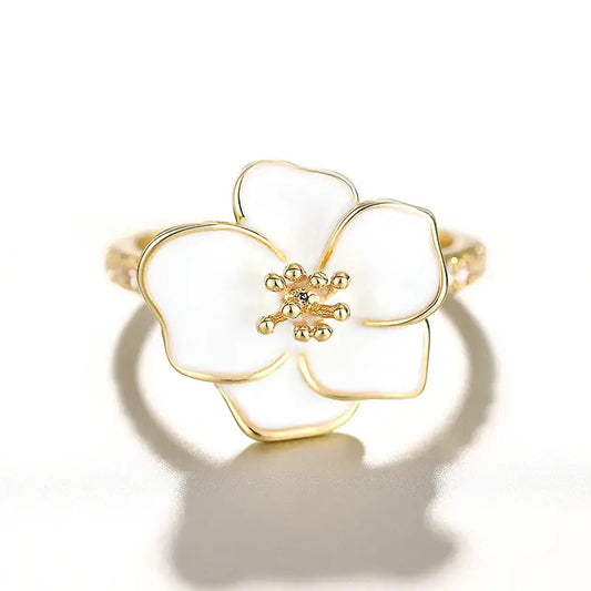 Bague en or ornée d’une fleur en émail blanc à cinq pétales.