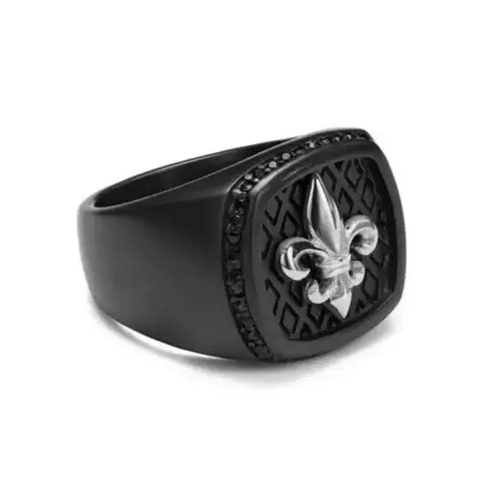 Bague noire présentant un symbole de fleur de lys sur une face texturée avec des accents de cristal.