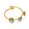 Bracelet manchette ouvert en or avec des grappes de perles colorées.