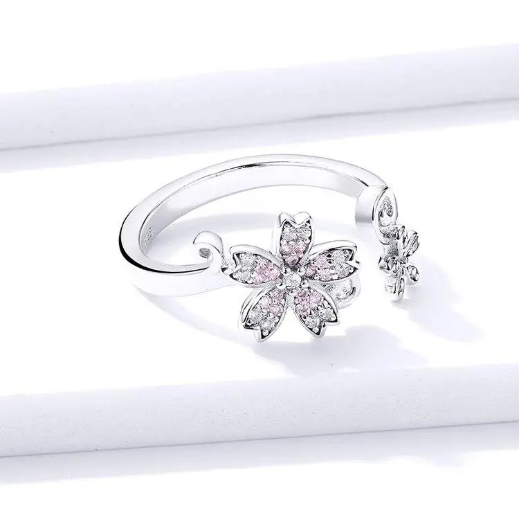 Bague fleur en argent avec accents roses.
