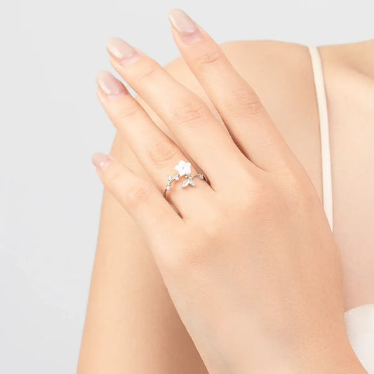 Bague en argent avec une pierre centrale en forme de cœur et de petites pierres d’accentuation sur la bande.