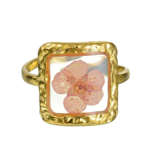 Bague en or avec une fleur rose pressée.