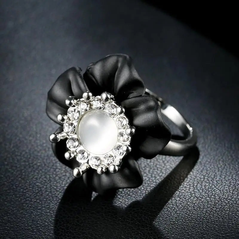 Bague fleur noire avec perle et cristal au centre.