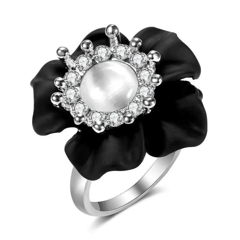 Bague fleur noire avec centre en perle et accents en cristal.