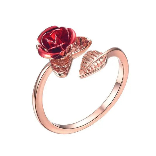 Bague en or rose représentant une rose rouge et des feuilles décoratives.