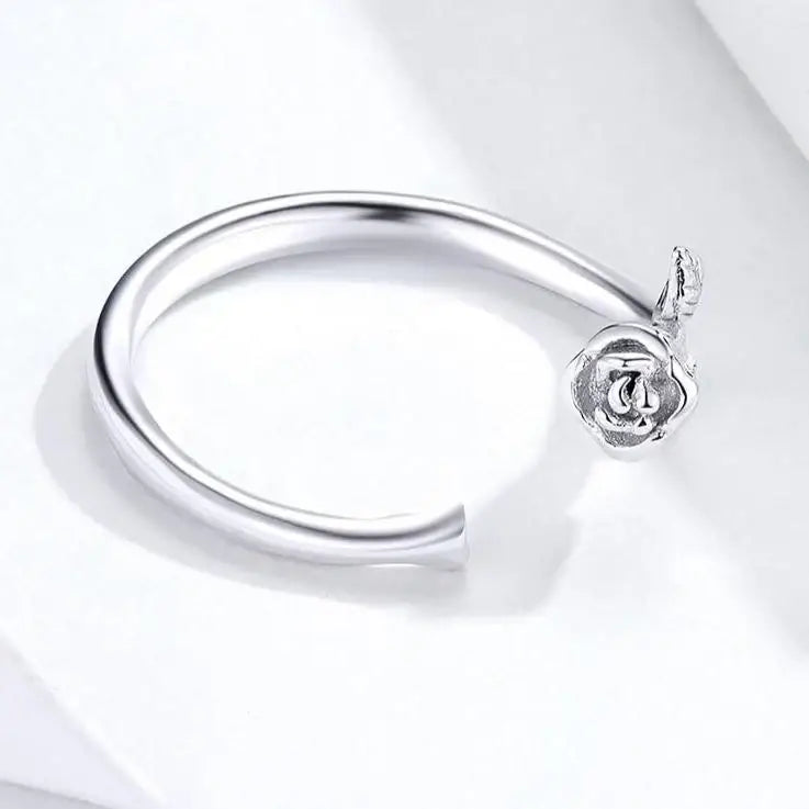Bracelet ouvert en argent avec une breloque en forme de rose.