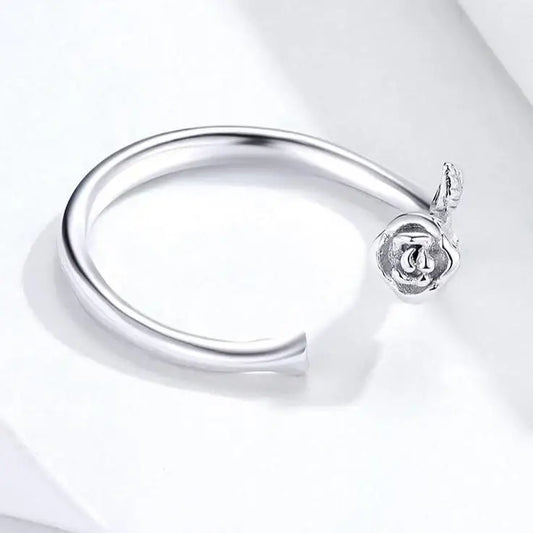 Bracelet ouvert en argent avec une breloque en forme de rose.