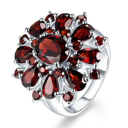Bague en argent présentant un motif floral en forme de grappe, réalisé avec des grenats rouge foncé.