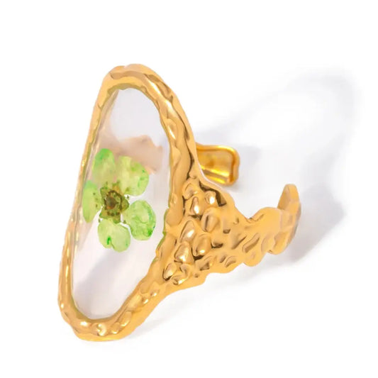 Bague en or avec fleur verte enchâssée.