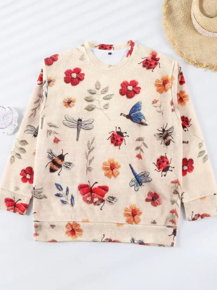 Sweat-shirt de couleur crème avec un motif de papillons, de libellules, d’abeilles et de fleurs rouges et orange.