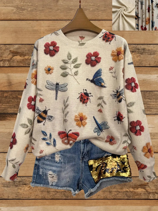 Sweat-shirt de couleur crème avec impression de fleurs et d’insectes représentant des papillons, des libellules, des coccinelles et des fleurs.